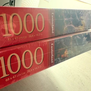 Wolf Castle & Sailor's Night (pussel, 2-pack) - Två färgsprakande 1000-bitars pussel! Wolf Castle visar en magisk varg framför ett sagoslott, medan Sailor's Night bjuder på en drömmig kust med fyr, hav och stugor. Perfekt för dig som gillar utmaningar och snygga motiv att hänga upp efteråt.