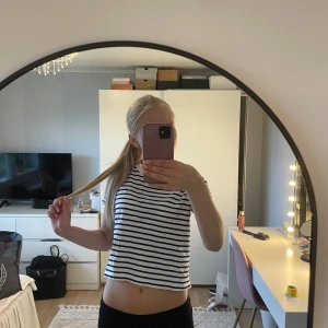 Randig croppad topp från Zara - Säljer en vit och marinblå randig croppad topp från Zara. Toppen har korta ärmar och en avslappnad passform, perfekt till jeans eller shorts. 