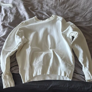 Vit sweatshirt från Marc O'Polo - Vit sweatshirt från Marc O'Polo med tryckt logga på ryggen. Tröjan har rund hals, långa ärmar och ribbade muddar vid ärmslut och nederkant. Tillverkad i mjuk bomull för en skön och avslappnad stil.              Den är i storlek S men passar M då jag kan ha den och är 182 cm 