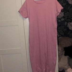 Rosa t-shirtklänning i bomull - Enkel och snygg rosa t-shirtklänning i storlek L. Klänningen har rund halsringning, korta ärmar 