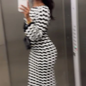 Svartvit långärmad mönstrad klänning - Säljer en svartvit långklänning med vågigt randigt mönster. Klänningen har långa ärmar och en kroppsnära passform som framhäver siluetten. Perfekt för dig som gillar att sticka ut med grafiska mönster.