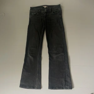 Svarta bootcut jeans Gina Tricot 146 - Snygga svarta jeans från Gina Tricot i storlek 146. Modellen har bootcut-ben, dubbla knappar i midjan och klassiska fickor både fram och bak med lock och silverfärgade knappar. 💗