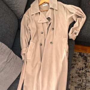 Trenchcoat - lång trendig trenchcoat från Gina Tricot i denim material, super skön, varm och i bra skick 💕