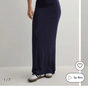 Mörkblå långkjol i stretchigt tyg - Säljer en stilren mörkblå långkjol med figurnära passform. Kjolen är enkel och rak i modellen, tillverkad i ett mjukt och stretchigt material som sitter snyggt på kroppen. Perfekt att matcha med sneakers eller sandaler för en avslappnad look. Använd fåtal gånger. 