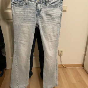 True Religion Joey Low Rise Flare Jeans - Ljusblå jeans från True Religion, modell Joey Low Rise Flare. Snyggt slitna med klassiska broderade bakfickor och silverfärgade knappar. Byxorna har låg midja och utsvängda ben. Byxorna är uppsydda några centimeter. Orginal pris 1299kr, köpta från Nelly