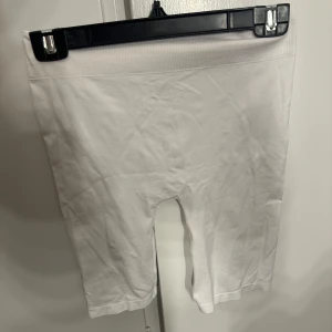 Vita cykelshorts från Vero Moda - Vita cykelshorts från Vero Moda i stretchig bomullskvalitet. De har en hög midja med bred resår och sitter tight mot kroppen. Perfekta för sommaren och enkla att matcha med oversized t-shirt eller hoodie.