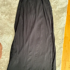 Svart plisserad långkjol - Säljer en svart plisserad långkjol från Gina. Passar dig som är runt 170 cm! Strl 36/38.