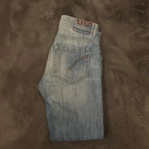 Ljusblå jeans från dondup - Säljer ett par ljusblå slim fit jeans från dondup i storlek 29/30. Jeansen har klassisk femficksdesign, slitna detaljer och snygg tvättad look. Materialet är jeans med en mjuk känsla och passformen är tight hela vägen ner.