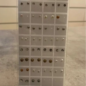 Set med 31 par örhängen i olika färger - Stort set med 31 par örhängen i olika stilar och färger. Innehåller pärlörhängen, glittriga stenar och klassiska bollar i silver och guld. Perfekt för dig som vill variera din look och matcha med olika outfits. Alla örhängen är små och diskreta, passar till flera hål i öronen.