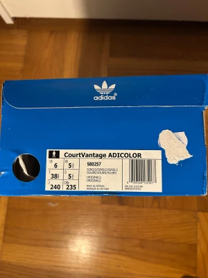 Adidas CourtVantage Adicolor sneakers - Fräscha Adidas CourtVantage Adicolor sneakers i en snygg ljus orange färg med matchande snörning och platt sula. Skorna har en stilren och minimalistisk design med rund tå och lågt skaft. Materialet är syntet med mjukt tygfoder för extra komfort. Strl i lagret: 38.5