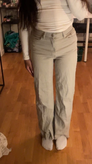 Beige jeans med hög midja - Säljer ett par snygga beige jeans med hög midja och wide fit. I mycket bra skick och säljs i befintlig skicka. Lite mindre i storlek. 