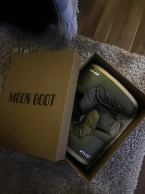 Moon boots - Moon Boots i färgen KHAKI. Perfekt för vinter och kalla dagar som håller dig varma. Dessa vinterskor är lite kortare än vanliga moon boots vilket gör att de inte syns lika mycket och inte tar lika mycket plats under byxan, men tillräckligt höga så att snön inte kommer åt. Färgen på skorna upplevs  mörkare än vad de egentligen är. Ny pris: 1999kr