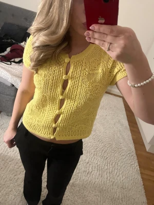 Gul stickad topp - Gullig gul stickad topp med knappar fram, kort modell som sitter fint i midjan. Helt ny utan lappar och perfekt till sommarens alla outfits 💛