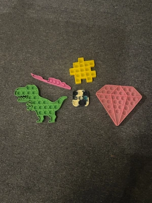 Fidget och sensoriska leksaker, mixad samling - Stor samling fidget- och sensoriska leksaker: pop-its, regnbågsfärgad slinky, pin art, snake puzzle, infinity cube och fler. Perfekt för stresslindring och koncentration. Alla delar i gott skick, inga synliga defekter eller slitage.