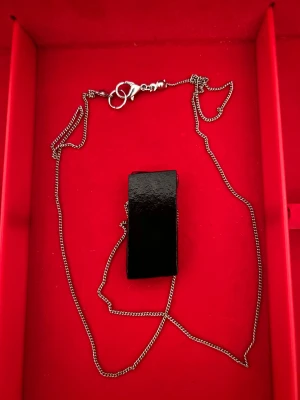 Halsband med blåmönstrad glasberlock - Unikt halsband med en rektangulär glasberlock i svart och blått med ett coolt geometriskt mönster. Kedjan är silverfärgad och har ett smidigt lås. Perfekt för dig som gillar att sticka ut med färg och form.