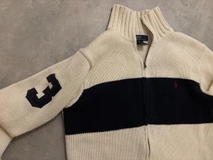 Beige och svart kofta från Polo Ralph Lauren - Riktigt fet zip tröja från Ralph lauren! Storlek är XL i barn men det sitter som S. Det finns lite slitage vid dragkedjan men som ni ser efter dem bilderna syns det inte när man knäppt den. Pris är ej hugget i sten!🪨💫