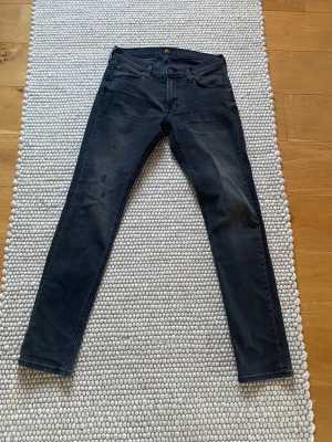 Lee Luke svarta - Snygga svarta jeans från Lee från med smal passform i storlek 29/32. Perfekta för dig som vill ha ett par stilrena jeans i garderoben. använda ett fåtal gånger men passar inte längre så därför säljs dem. 