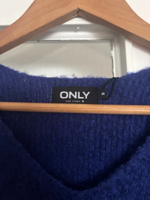 Blå stickad tröja med v-ringning ONLY - Mysig blå stickad tröja från ONLY i storlek M. Tröjan har en snygg v-ringad hals och långa ärmar. Perfekt för dig som gillar enkel och stilren design med en mjuk känsla. Passar dig som vill ha en klassisk look med lite extra färg.