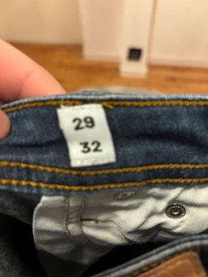 Slim Glenn jeans mörkblå 29/32 - Mörkblå jeans från Slim Glenn i modellen slim fit. Klassisk femficksdesign med snygga kontrastsömmar och normal midja. Jeansen är tillverkade i jeansmaterial och har en rak, smal siluett som sitter snyggt på benen.