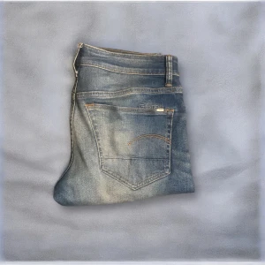 G-Star Raw jeans Slim - G-Star Raw Jeans! En av de trendigaste och mest populära modellerna just nu inför hösten i en rimlig budget🔥 Skick: 9/10 Nypris: ca 2000 kr Säljs för: 299 kr 💸 Jeansen har originalslitningar från fabrik som ger den där ikoniska G-Star-looken – stilrena, bekväma och sjukt snygga både till vardags och fest. 💬 Skriv vid minsta fundering! Priset är inte hugget i sten, så passa på innan de försvinner 🙌😎