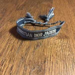 Christian dior armband - Ett marinblått Christian dior armband. Det går att justera storleken