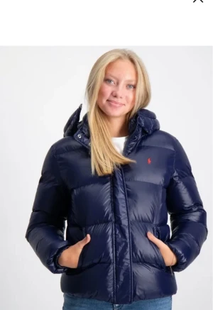Ralph lauren jacka  - Säljer en super populär mörkblå pufferjacka från Polo Ralph Lauren. Jackan har huva, dragkedja och knappar framtill samt två stora fickor. Fodrad och riktigt varm. Storlek 170 i jackan men motsvarar ungefär storlek s. Den är väldigt eftertraktad och säljs inte längre🥰är öppen för att diskutera priset!