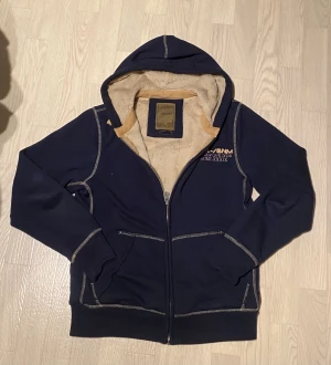 Mörkblå fleecefodrad hoodie(vintage) - Mörkblå hoodiejacka från poolman med mysigt beige fleecefoder. Skick 8/10. Det är storlek M. Bara höra av dig vid funderingar😁