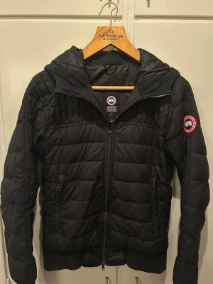 Canada Goose cardigan  - Tjena! Säljer nu en riktig fet Canada goose cabri hoody med huva och klassisk logga på ärmen. Den är använd ett fåtal gånger och har små defekter. Storlek: S men passar även M. Skick: 7/10. Priset kan såklart alltid att diskuteras. Hör av er vid frågor!