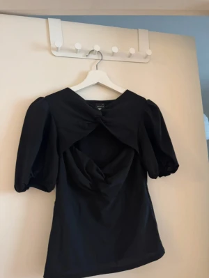Svart topp med knyt och puffärm - Säljer en svart topp som passar perfekt till både vardags och lite mer uppklätt! 