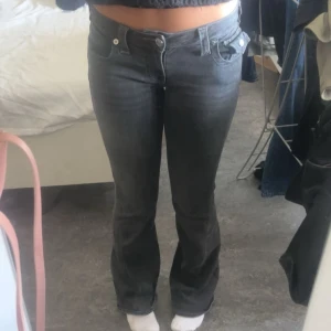 True Religion svarta bootcut jeans - Säljer ett par svarta jeans från True Religion med bootcut passform och låg midja. Storlek w25. dom har ett hål mellan bena ner vid låret, men annars i bra skick❤️