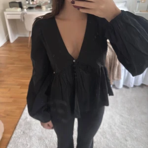 Svart blus från Nelly  - Svart blus från Nelly med djup v-ringning, aldrig använd och med prislapp kvar🥰