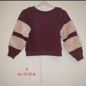 Vinröd lila tröja med beige pälsdetaljer - En tröja med fluffiga ärmar för flickor mellan 10- 12 år. Perfekt nu för den kalla säsongen😍❄️Supermjuk och skön att ha på sig.