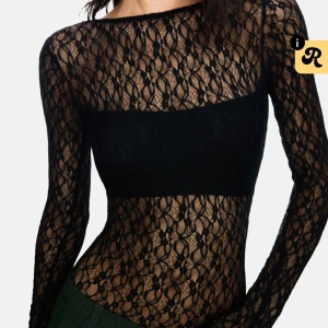 Svart spetsbody med öppen rygg - Säljer en svart långärmad body i transparent spets med blommigt mönster. Toppen har en tight passform och en snygg öppen rygg. Oanvänd med prislappkvar! Varan är slutsåld!