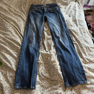 Blå raka low waist jeans från Nelly - Snygga blå jeans från Nelly med klassisk femficksdesign och raka ben. Jeansen har normal midja och är tillverkade i slitstarkt denimtyg. Perfekta för dig som gillar en enkel och tidlös look med lite loose passform.