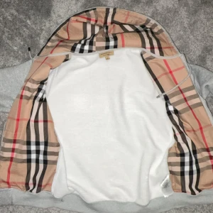 Grå hoodie från Burberry - Köpte denna i Londen för nått år sen, den har hängt på en galja sedan dess. Nästa helt oanvänd! ⚠️Obs! Finns inget kvitto⚠️                                                                              Storlek M.                                                                          Nypris (4000kr).  Mitt pris (1000).                           Vid snabb och smidig affär kan vi diskutera om priset! Hör av dig vid minsta lilla fråga!  