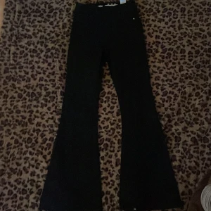 Svarta bootcut byxor - Snygga svarta byxor med bootcut-snitt som ger en schysst siluett. Perfekta för dig som gillar en klassisk look med lite extra vidd nedtill. Byxorna har en enkel design utan synliga detaljer och passar till många olika stilar.