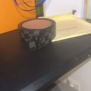 rutig skinnbälte - Säljer ett snyggt  bälte i svart och grått med klassiskt rutigt mönster . Bältet är gjort i skinn och har en lyxig känsla med brunt insida. Perfekt för dig som vill ha en statement-accessoar.