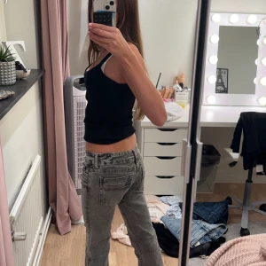Gina tricot young Grå bootcut jeans med rå kant  - Supersnygga gråa jeans från Gina Tricot Young, i en lätt blekt tvätt som ger ett coolt, nästan mönstrat utseende! Modellen har låg midja (low waist) med justerbar resår på insidan för bästa passform. Benen är smala upptill och utsvängda nertill (bootcut/flare), och har en rå kant nertill eftersom jag sprättat upp fållen tidigare.Säljer eftersom de är lite för korta för mig och jag skulle behöva en storlek större.