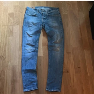 Dondup jeans med slitningar  - Snygga dondup jeans i klassisk blå tvätt med slitningar och detaljer på bakfickorna. Modellen har raka ben och slim/skinny fit, med coola slitna partier framtill. Ny pris runt 1899 mitt pris 549 säljer dessa då de har blivit för små passformen är 60 kg och 178 cm ish pris går att diskutera! OBS, ser även bättre ut i verkligheten då ja har en dålig kamera! 