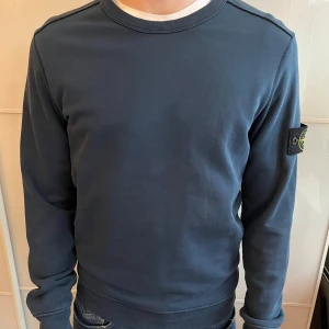 Mörkblå Stone Island sweatshirt - Säljer en mörkblå sweatshirt från Stone Island med klassisk patch på vänster ärm. Köpt på nk 