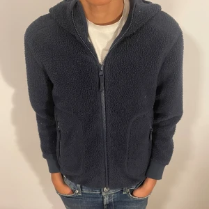 Mörkblå teddyjacka med huva - Mysig mörkblå teddyjacka med huva och hel dragkedja framtill. Barnstorlek 10/140. Pris kan diskuteras vid snabb affär 