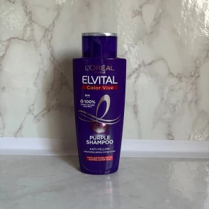 L'Oréal Elvital Color Vive Purple Shampoo - Lila flaska med L'Oréal Elvital Color Vive Purple Shampoo, 200 ml. Speciellt framtagen för att neutralisera gula och orange toner i blont, slingat eller silverfärgat hår. Ger en kallare nyans och fräschare look.
