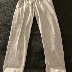 Grå mjukisbyxor från H&M - Sköna grå mjukisbyxor från H&M i regular/baggy fit som passar perfekt till att ha hemma på chill dagar, nyligen köpta men växte ur dem väldigt snabbt, nypris 249kr