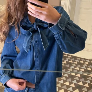 Blå denimskjorta  - Snygg blå denimskjorta/blus från & Other Stories med knytband i halsen. Av någon anledning är lappen med storleken avklippt, men den passar mig med storlek S💕öppen för prisförslag