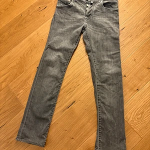 Grå Jacob Cohen jeans 688 Comfort - Snygga grå jeans från Jacob Cohen, modell 688 Comfort. De har raka ben, lila broderade detaljer och knappar framtill.Perfekt för dig som gillar stilrena och unika jeans.