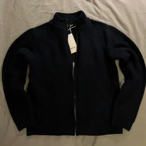 Mörkblå stickad kofta med dragkedja - Väldigt snygg stickad cardigan från märket LIMITED. Extremt bra passform och är väldigt stilren. Helt oanvänd och lappar finns kvar. Storlek: 13-14 S