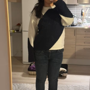  stickad tröja med mönster - Snygg stickad tröja i mörkblå och vitt med ett coolt, asymmetriskt mönster över hela framsidan och ärmarna. Tröjan har rund hals och långa ärmar, perfekt för dig som gillar en lite unik stil. Passar dig som vill ha något som sticker ut i garderoben.