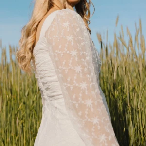 Den perfekta studentklänningen! - Superfin vit kort klänning med transparenta långa spetsärmar och söt broderad blomdetalj. Klänningen har en lätt v-ringad byst och figurnära passform upptill. Perfekt för student eller sommarens alla tillfällen! Endast använd på min student i somras! Nypris 899kr. Ställ gärna frågor eller kom med prisförslag! Hör gärna av er innan ni trycker på köp!!!