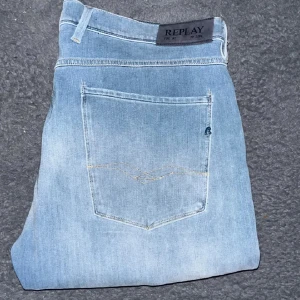Replay jeans  - Säljer ett par ljusblå jeans från Replay med klassisk femficksdesign och diskreta slitningar. Jeansen har slim passform och raka ben, tillverkade i mjukt denimtyg. Perfekta för dig som gillar en stilren och avslappnad look. Som man ser på sista bilden så har jeansen blivit lite blekta och fläckiga vid framfickan. Och som man ser på bild 2 har ena knäet fått lite mörkare färg, i övrigt mycket bra skick. JAG SKICKAR INGA FLER BILDER NÄR JAG BÄR JEANSEN! Längd 108, midja 47cm (S)