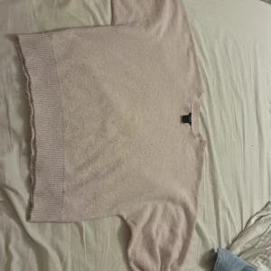 Ljusrosa stickad tröja från Lindex  - Supermysig ljusrosa stickad tröja från Lindex med breda muddar och rund hals. Tröjan har en loose passform och långa ärmar, perfekt för lager på lager. Enkel och stilren design som är lätt att matcha med jeans eller kjol.